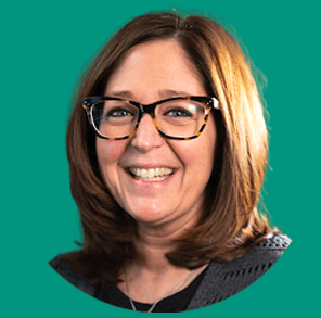Smiling woman with glasses and shoulder-length brown hair against a teal background.